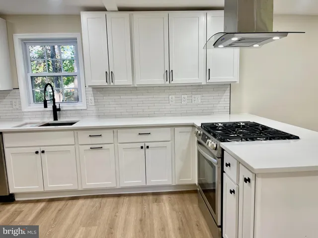 a kitchen with granite countertop white cabinets and white appliances
