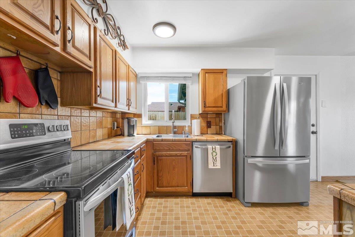 1640 Emerald Place Reno, NV 89502 - Photo 11 of 25 a kitchen with stainless steel appliances granite countertop a refrigerator a stove and a sink with cabinets
