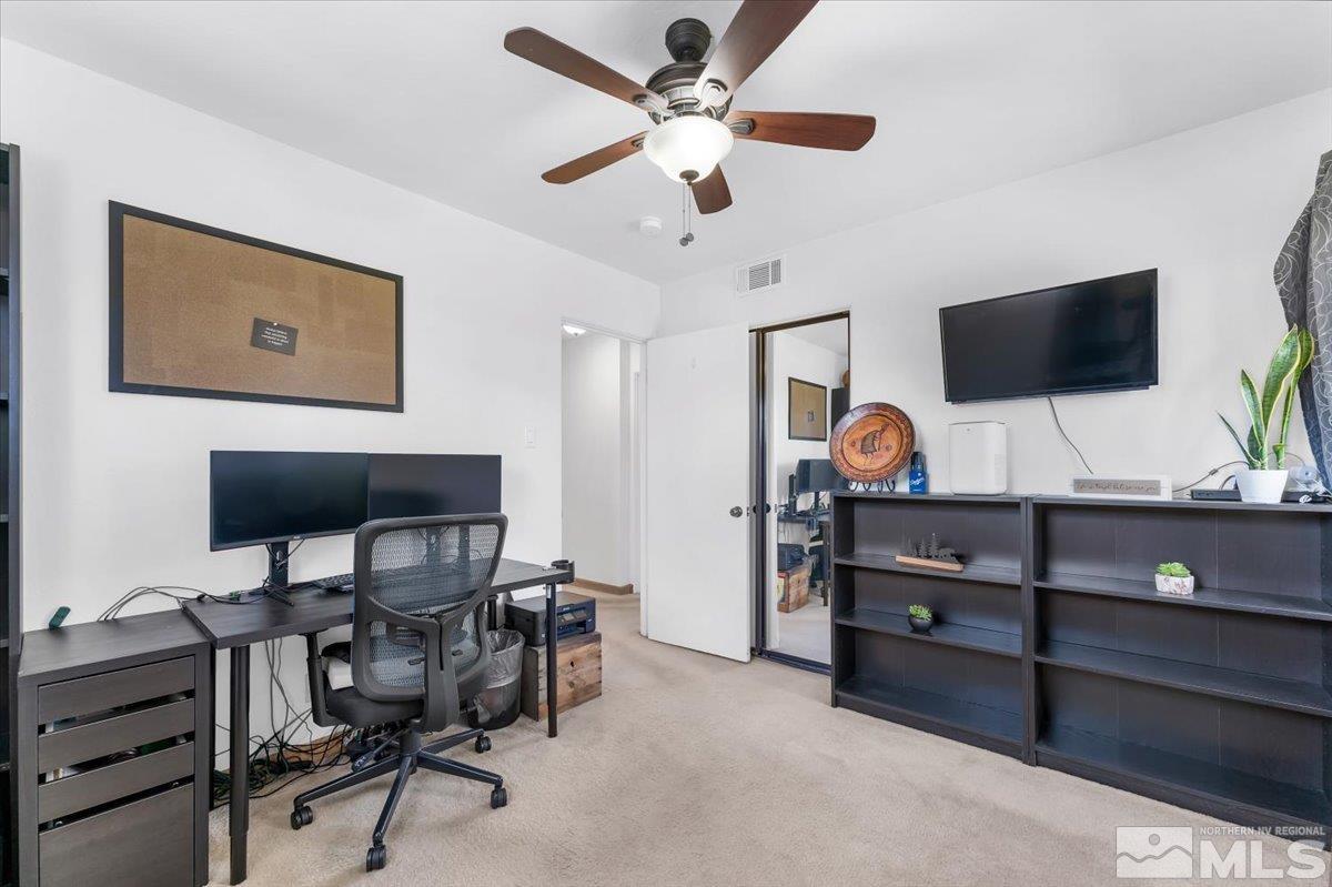 1640 Emerald Place Reno, NV 89502 - Photo 17 of 25 a view of a workspace with a flat screen tv and a ceiling fan