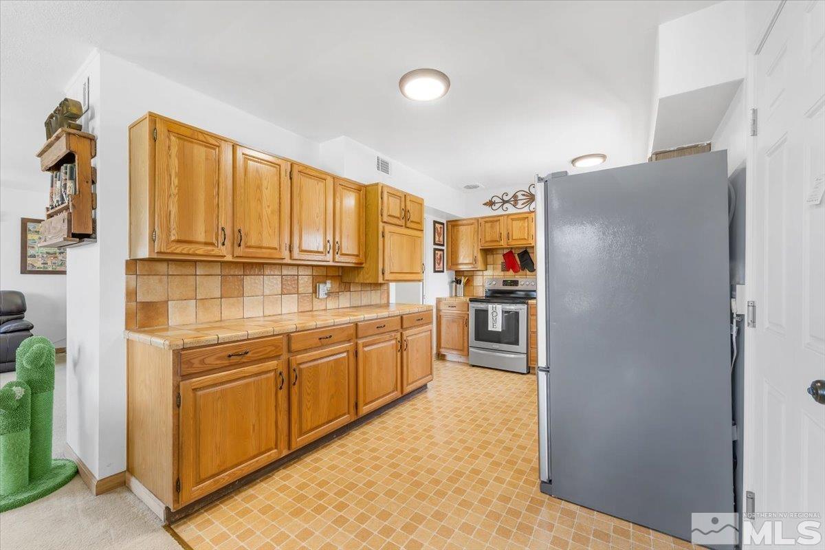 1640 Emerald Place Reno, NV 89502 - Photo 9 of 25 a kitchen with stainless steel appliances granite countertop a refrigerator and a stove top oven