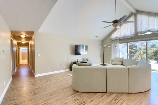 a dining room with wooden floor a chandelier a wooden table and chairs