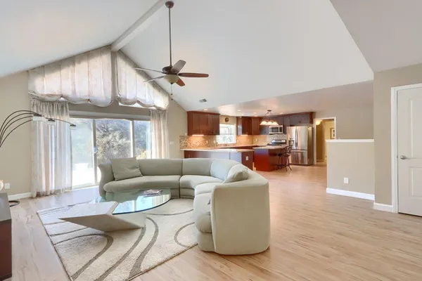 a living room with furniture wooden floor and a window