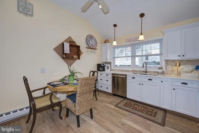 a kitchen with a dining table chairs and white cabinets