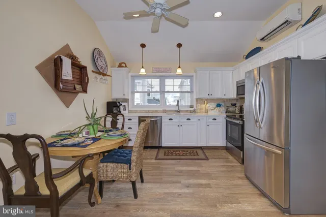 a kitchen with cabinets a sink stainless steel appliances and a window