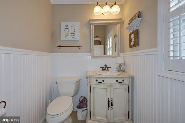 a bathroom with a toilet a sink and mirror
