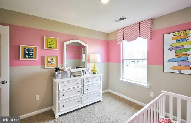 a bedroom with a dresser and a window