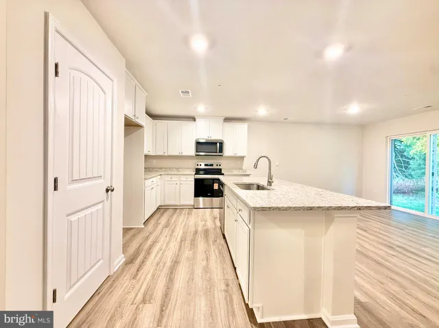 a kitchen with a sink a stove top oven and cabinets