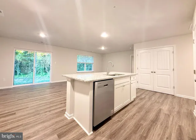 a kitchen with a sink wooden floor and white cabinets