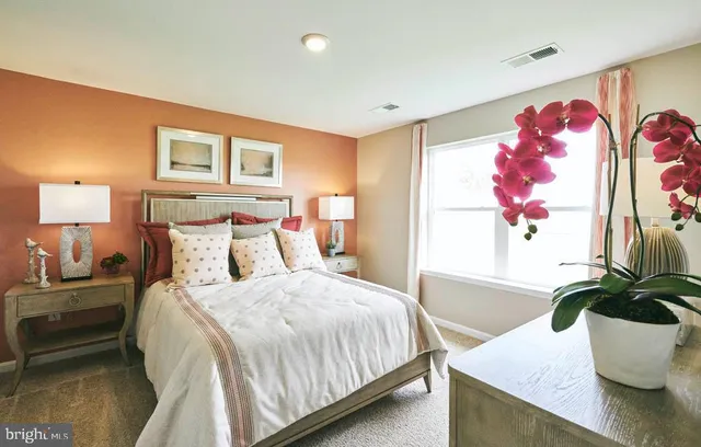 a bedroom with a bed and a potted plant