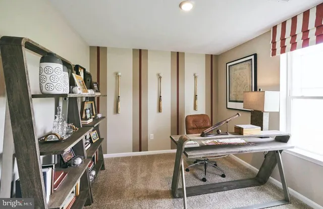 a view of a workspace with furniture and a window