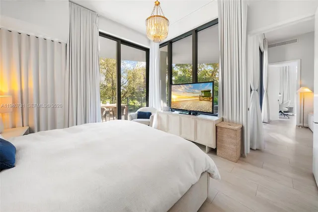 a bedroom with a large bed and a chandelier