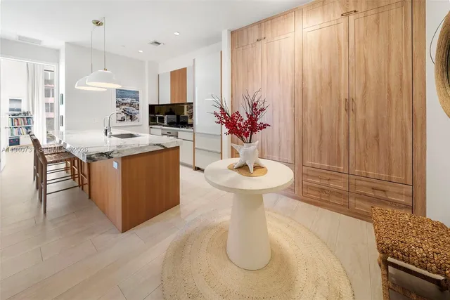 a kitchen with stainless steel appliances kitchen island a sink a table and chairs