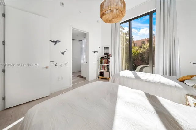 a bedroom with a bed and a large window