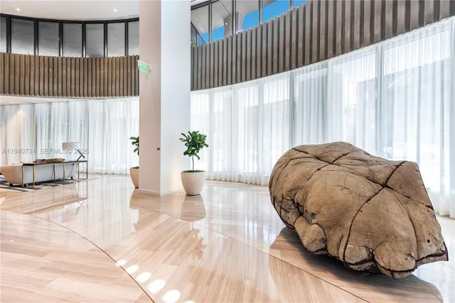 a bedroom with a bed and large windows