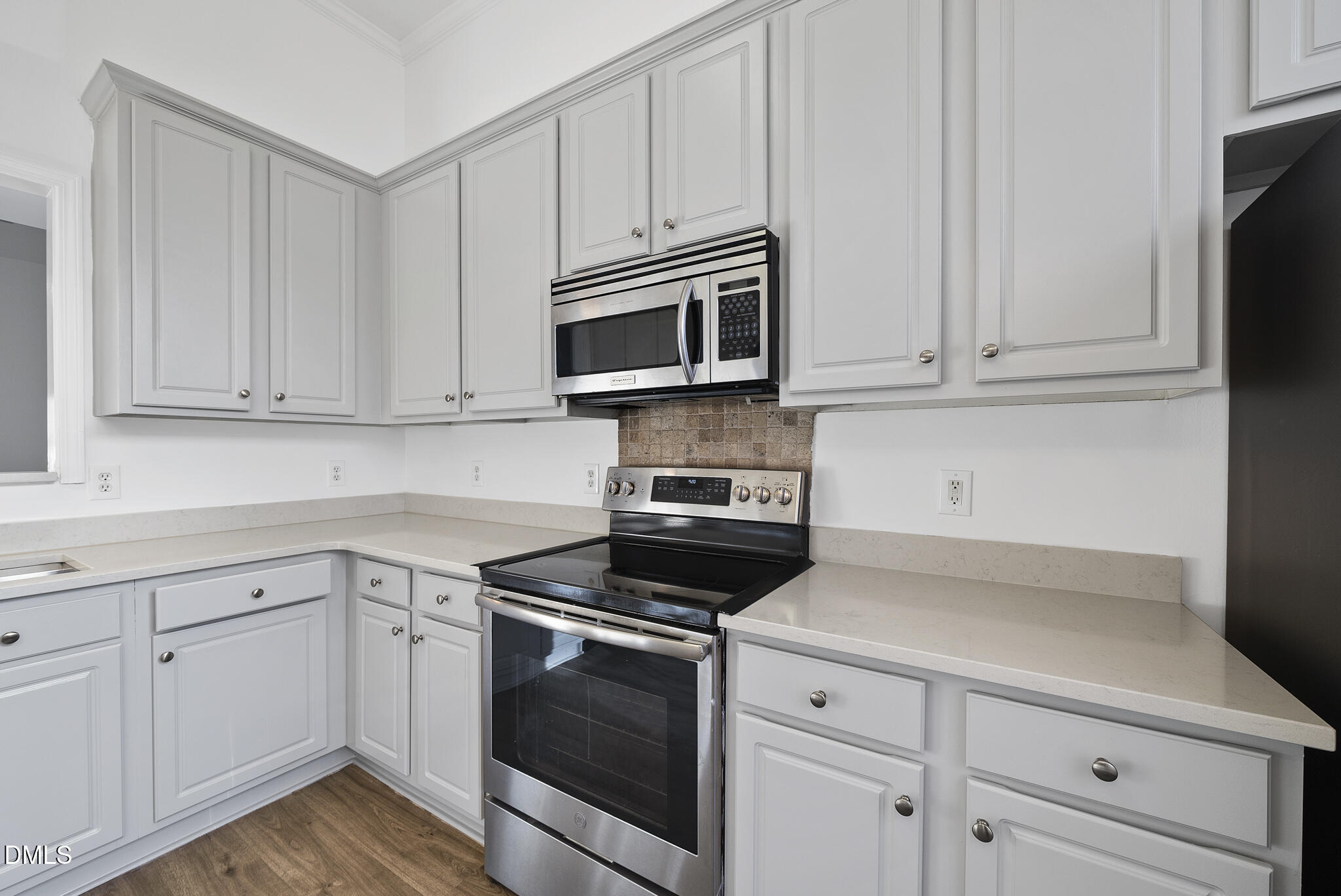 6 Cibola Court Durham, NC 27713 - Photo 6 of 30 a kitchen with white cabinets and stainless steel appliances