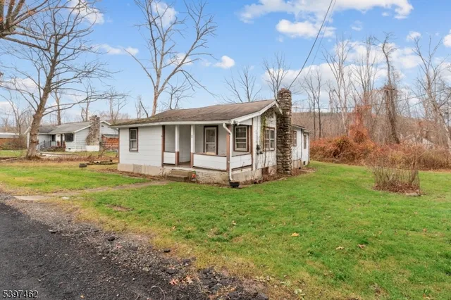a view of a house with backyard and a tree