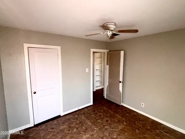 a view of a livingroom with a chandelier fan and wooden floor