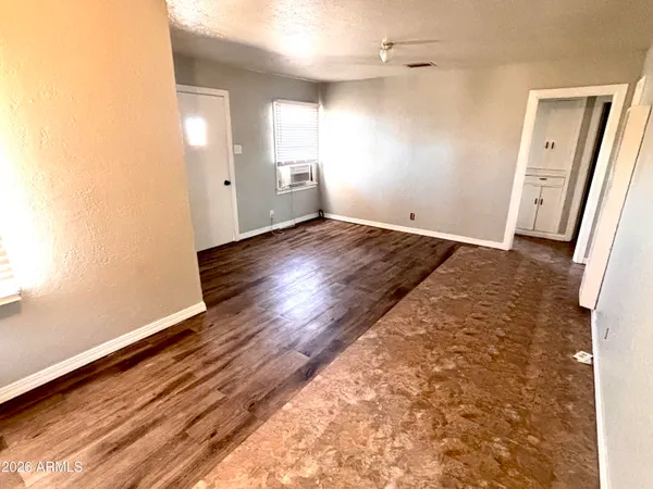 an empty room with wooden floor and windows