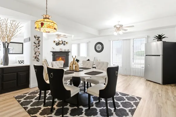 a dining room with wooden floor a chandelier a wooden table and chairs