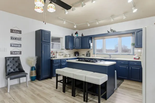 a kitchen with stainless steel appliances granite countertop a table chairs and a refrigerator