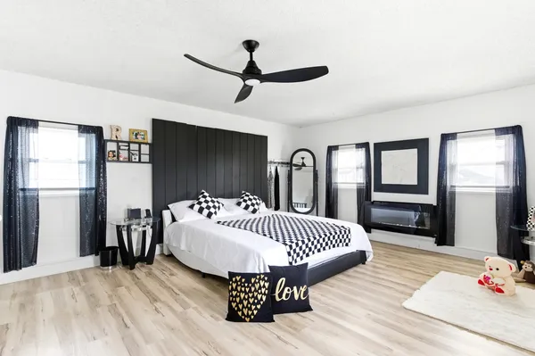 a bedroom with a bed and a large mirror with wooden floor