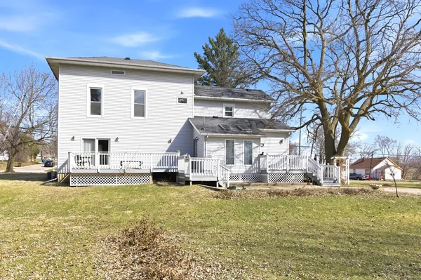 a view of a house with a big yard and large tree