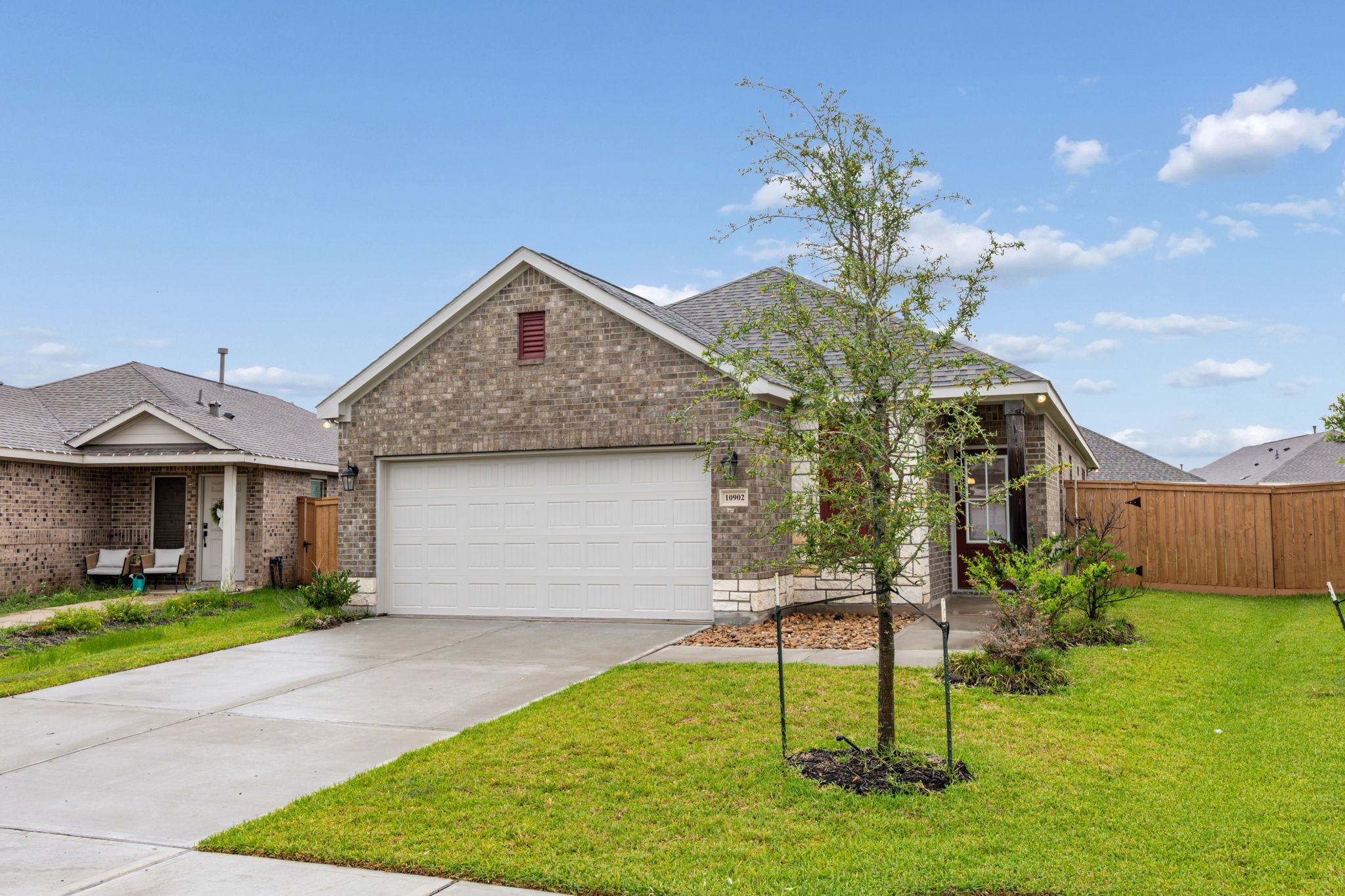 10902 Bonfire Trail Beasley, TX 77417 - Photo 35 of 36 Charming single-story brick home with a two-car garage and a welcoming front porch. It features a well-maintained lawn, baby tree, and a private fenced backyard.