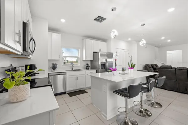 a kitchen with a sink a counter top space appliances and cabinets