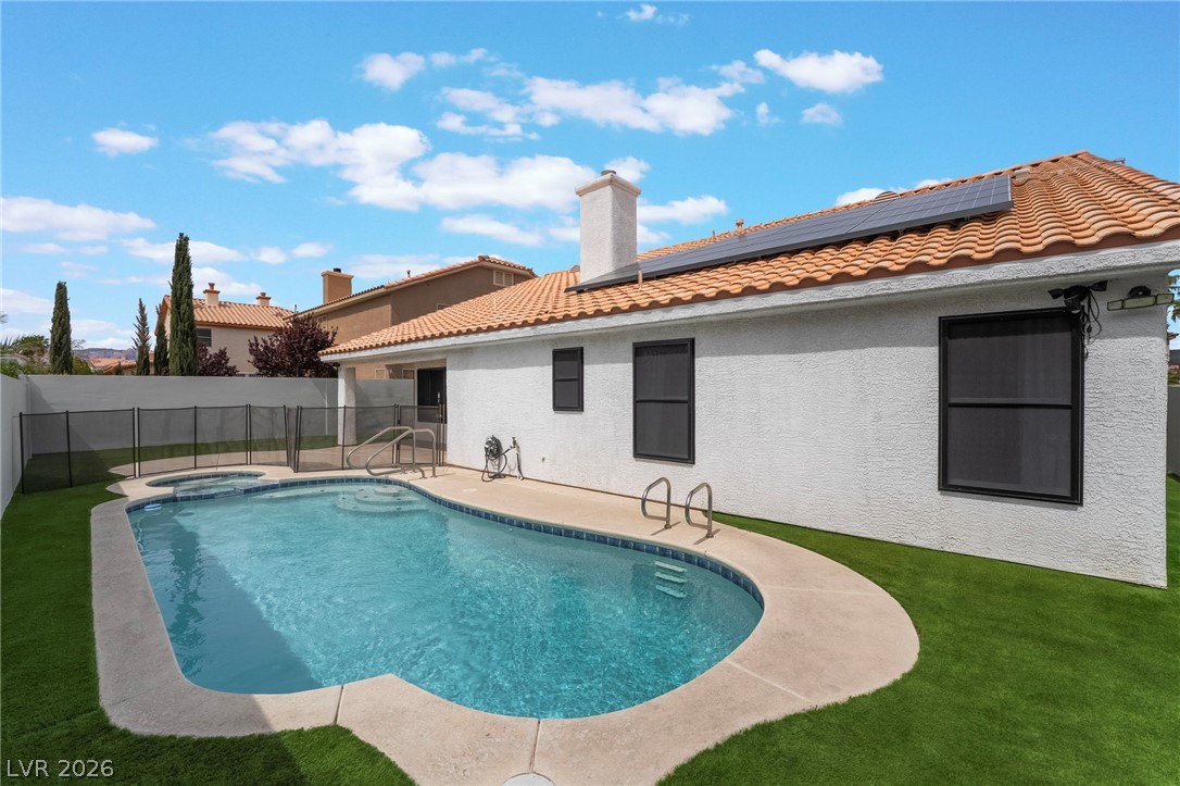 9171 West Viking Road Las Vegas, NV 89147 - Photo 41 of 43 An inviting backyard oasis awaits with a sparkling pool, integrated spa, and manicured artificial turf.