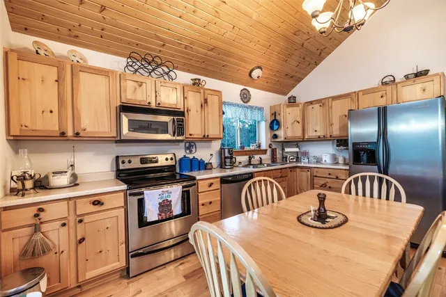a kitchen with stainless steel appliances kitchen island granite countertop a sink a stove and a wooden cabinets