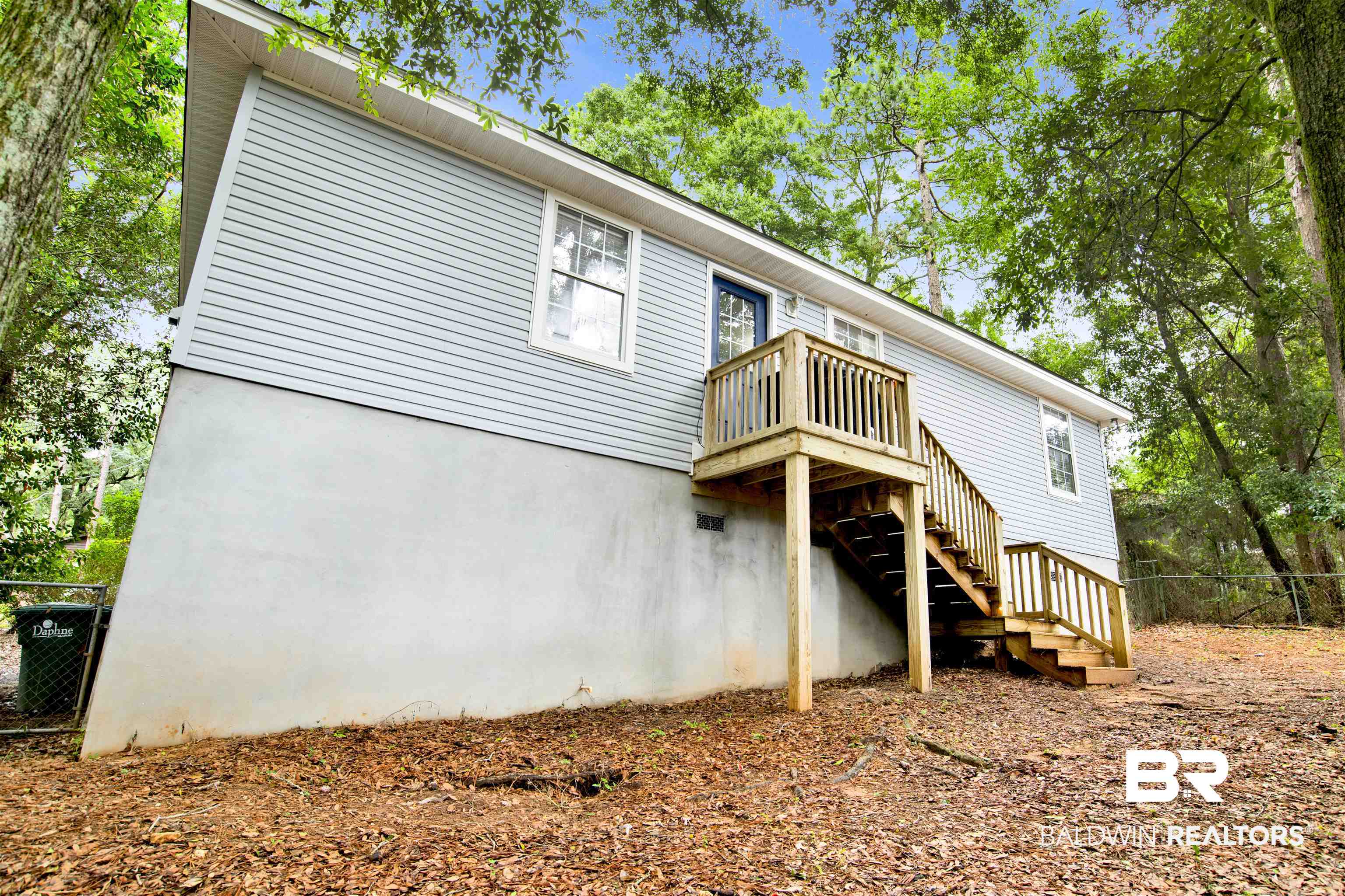 253 Maplewood Loop Daphne, AL 36526 - Photo 3 of 30 Rear exterior featuring light blue horizontal siding and a two-story wooden deck with stairs