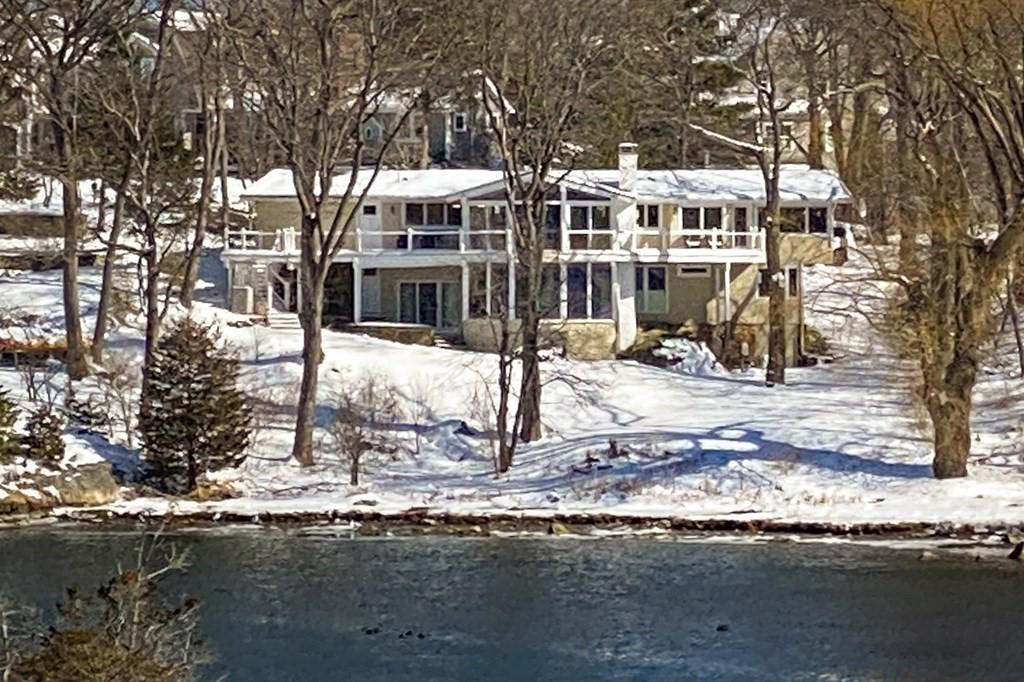 a view of a large building with large tree and wooden fence