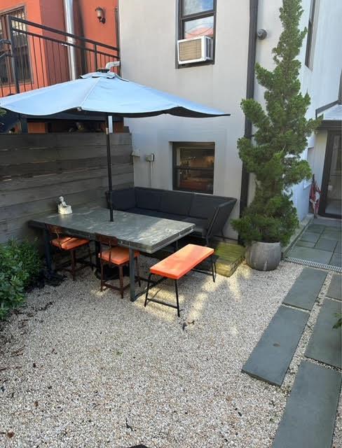 a backyard of a house with barbeque oven table and chairs