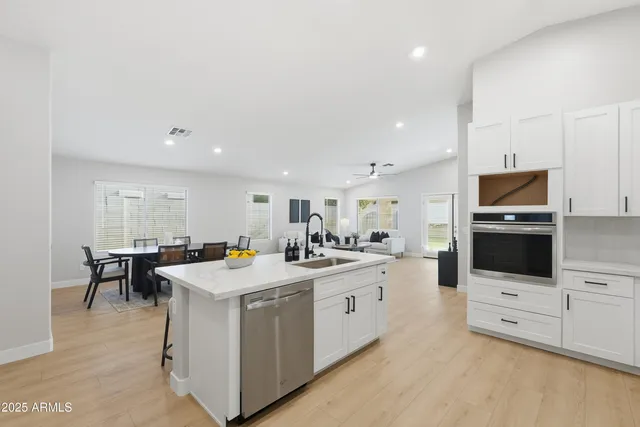 a kitchen with stainless steel appliances kitchen island granite countertop a stove and a sink