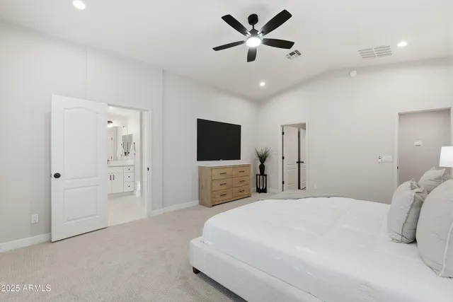 a bedroom with a large bed and a flat screen tv