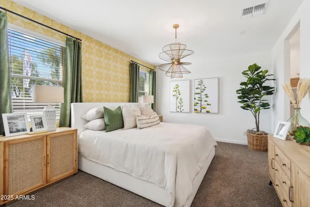 a bedroom with a large bed and a chandelier