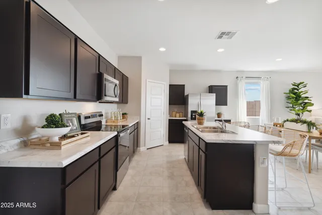 a kitchen with counter top space a sink stainless steel appliances and cabinets