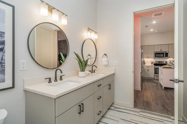 a en suite bathroom with a double vanity sink and a mirror