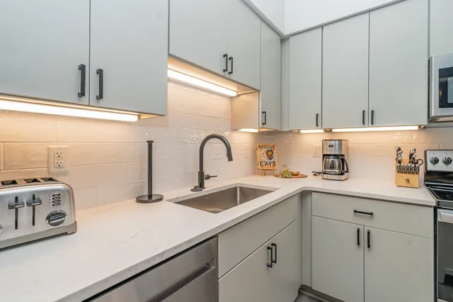 a kitchen with a sink a stove and cabinets