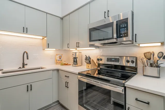 a kitchen with a sink stove and microwave