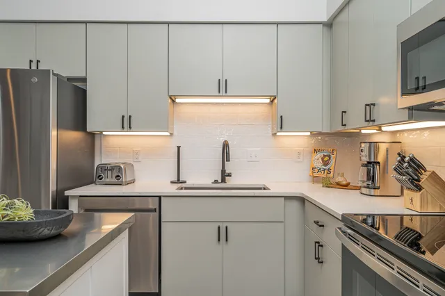 a kitchen with stainless steel appliances a sink a stove and a refrigerator