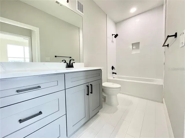 a bathroom with a sink a toilet and a large mirror