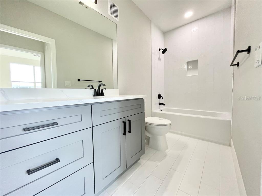 4221 West Spruce Street, Unit 2401 Tampa, FL 33607 - Photo 13 of 22 a bathroom with a sink a toilet and a large mirror