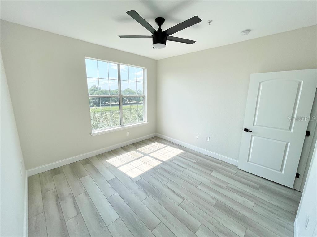 4221 West Spruce Street, Unit 2401 Tampa, FL 33607 - Photo 14 of 22 an empty room with wooden floor and windows