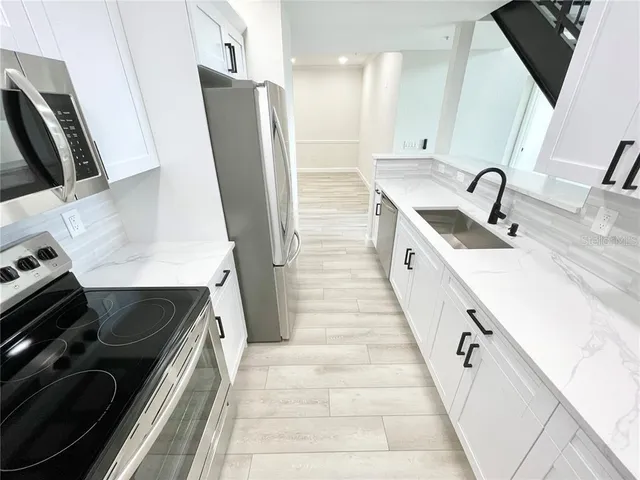 a kitchen with sink a refrigerator and a stove