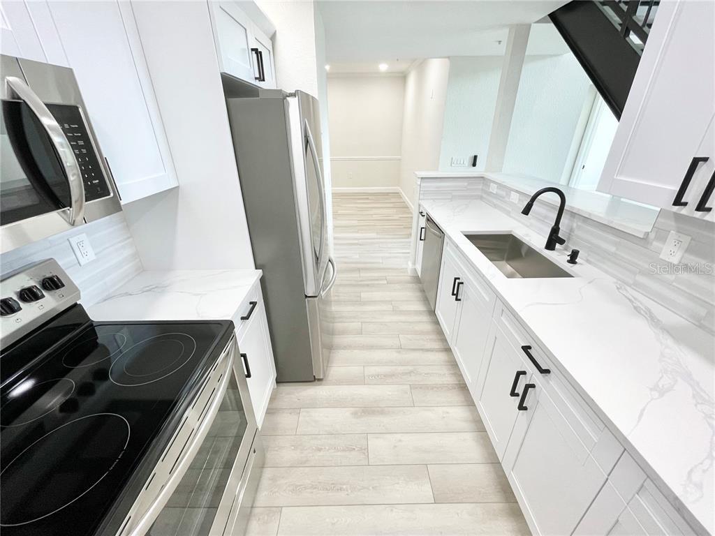 4221 West Spruce Street, Unit 2401 Tampa, FL 33607 - Photo 4 of 22 a kitchen with sink a refrigerator and a stove