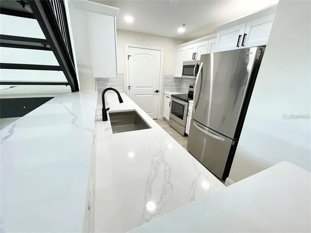 a kitchen with stainless steel appliances a refrigerator and a stove