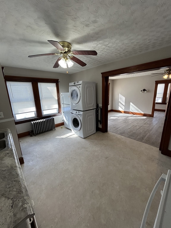 a view of a livingroom with a staircase a ceiling fan and a rug