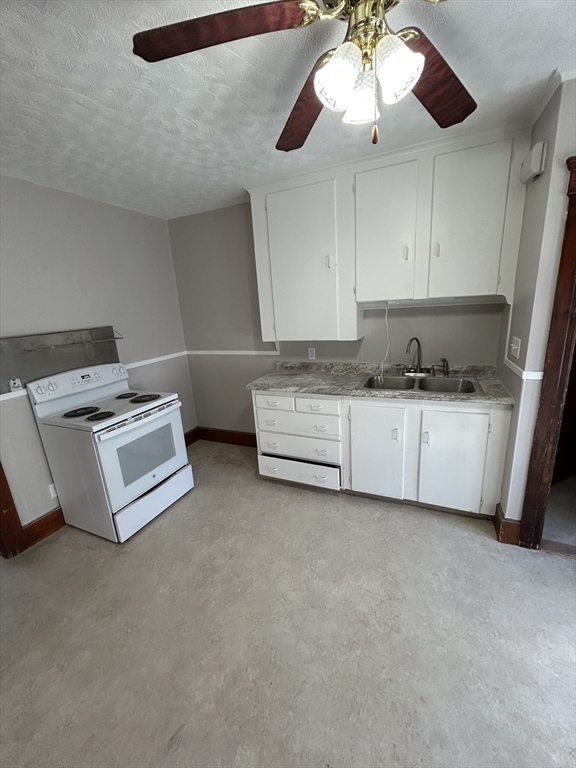 6 Boyden Street, Unit 1F Webster, MA 01570 - Photo 2 of 7 a kitchen with stainless steel appliances a stove a sink and white cabinets