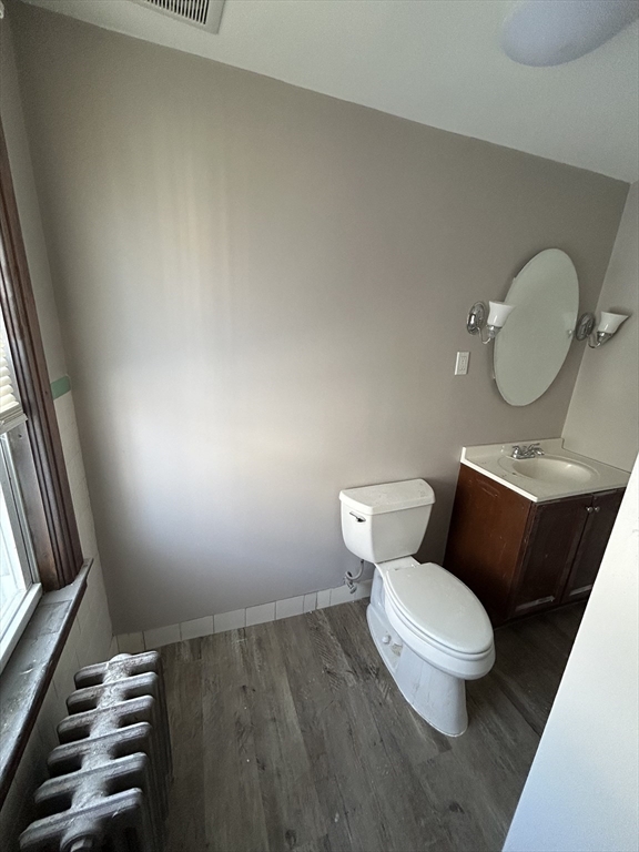 6 Boyden Street, Unit 1F Webster, MA 01570 - Photo 7 of 7 a white toilet sitting next to a bathroom sink and a mirror